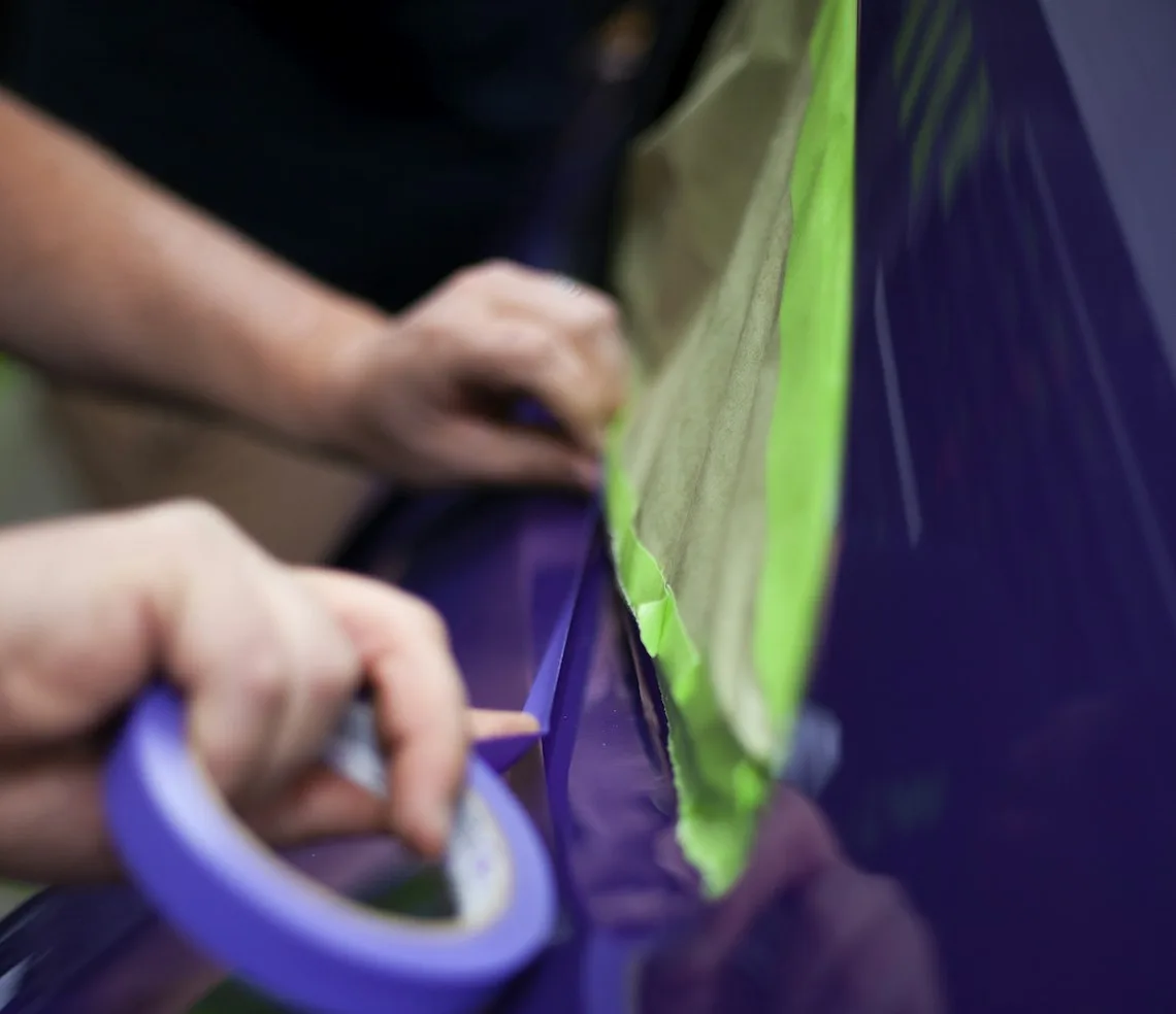 A fitter smoothing film onto a car window