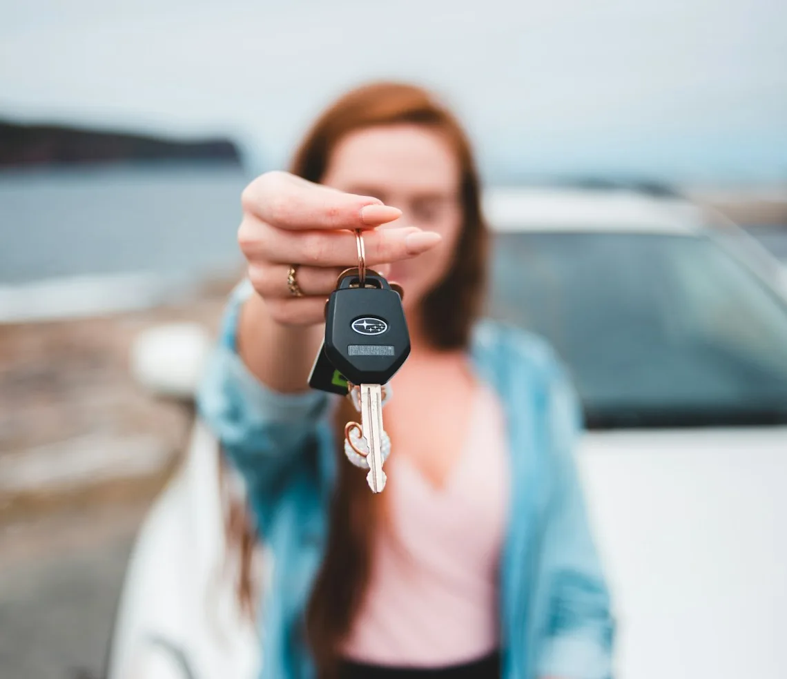 A rental manager holding out the keys to a car