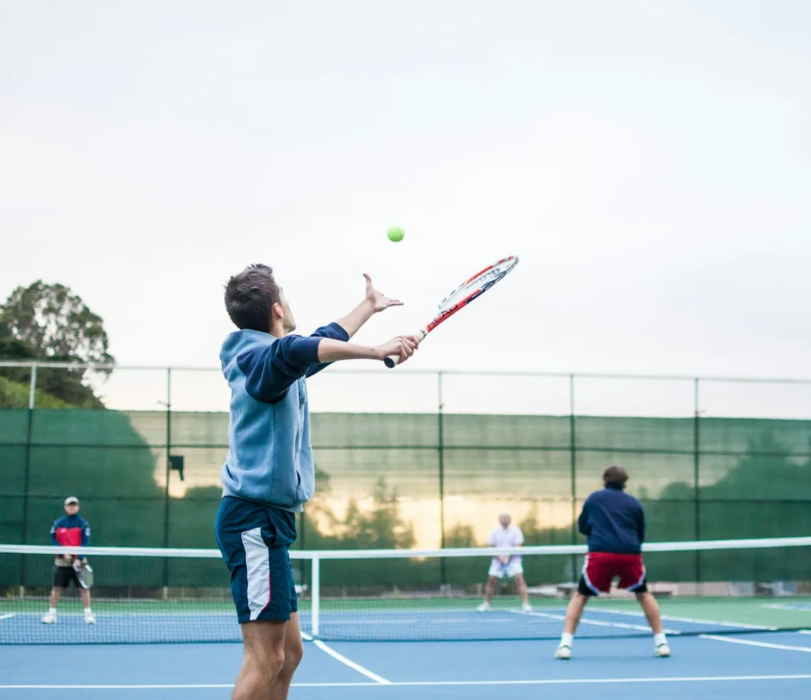 A player serving on court while the opponents wait across the net