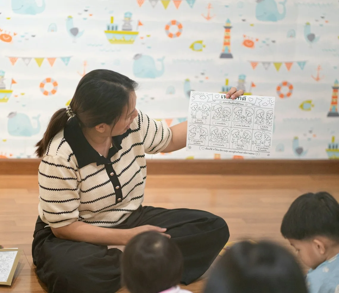 A teacher showing children a picture during a class at a learning centre