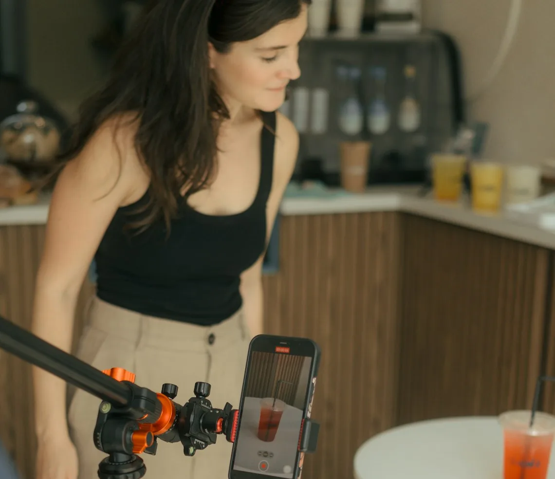 A UGC creator filming a product on a phone mounted on a gimbal