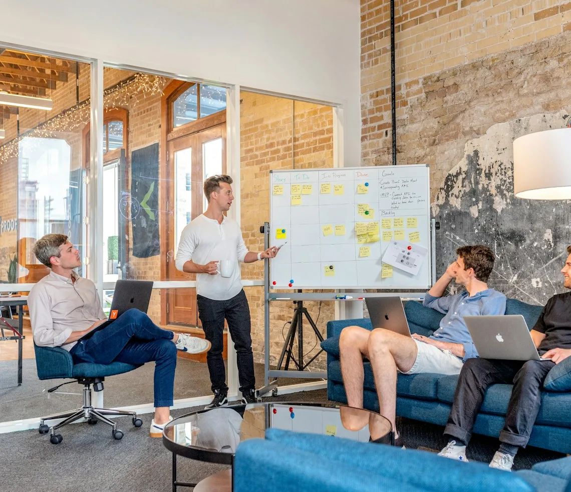 An agency team going over a campaign at a board covered in sticky notes