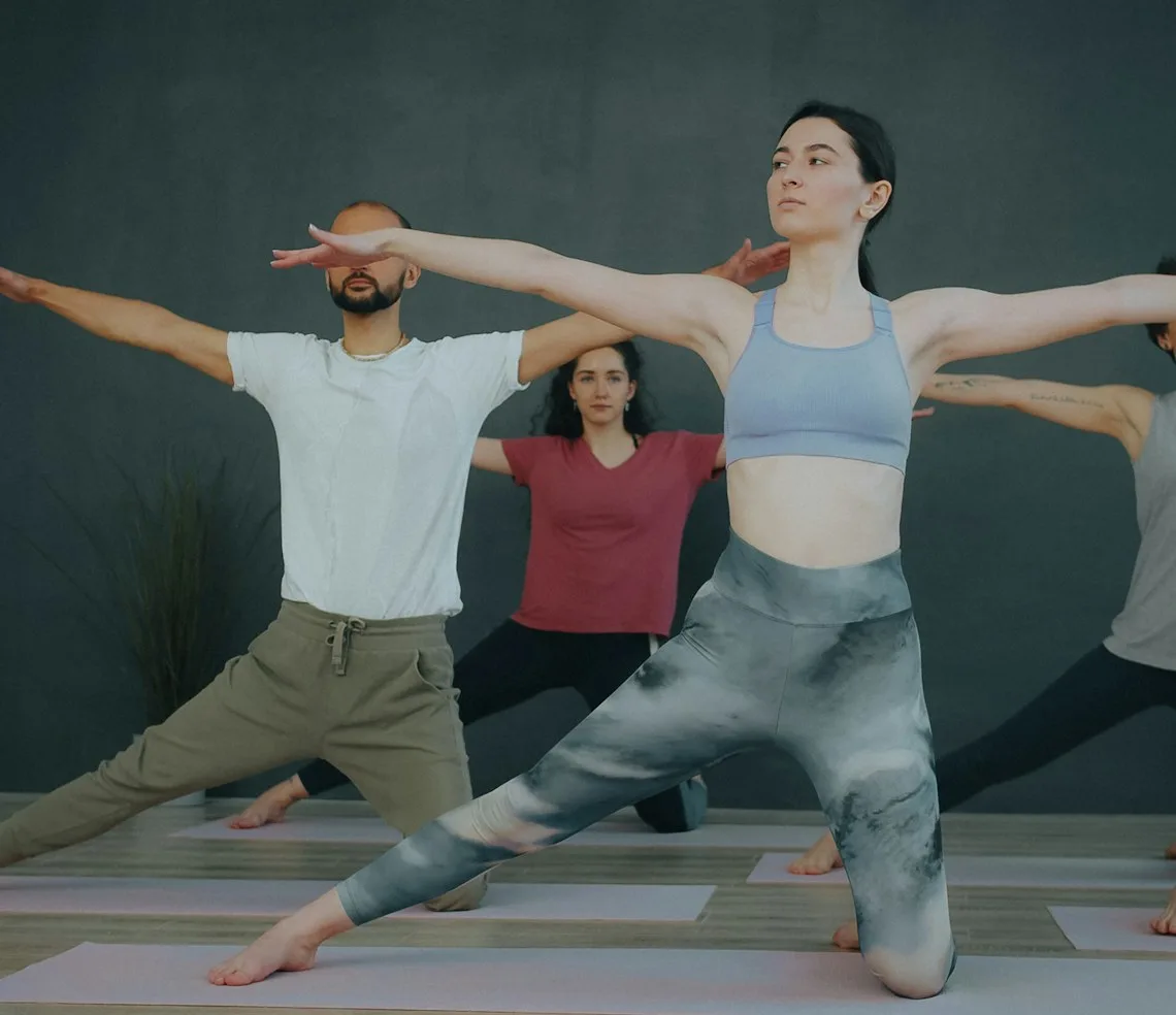 A group holding a pose on their mats in a yoga studio