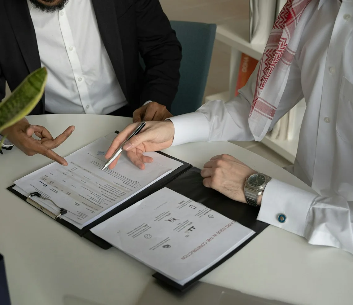 A financial adviser going through documents with a client at a desk