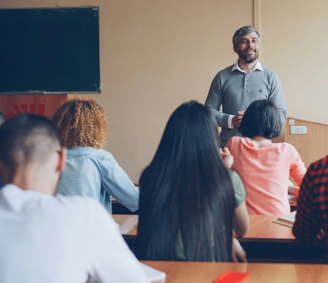 A teacher leading a class in front of a group at a language school