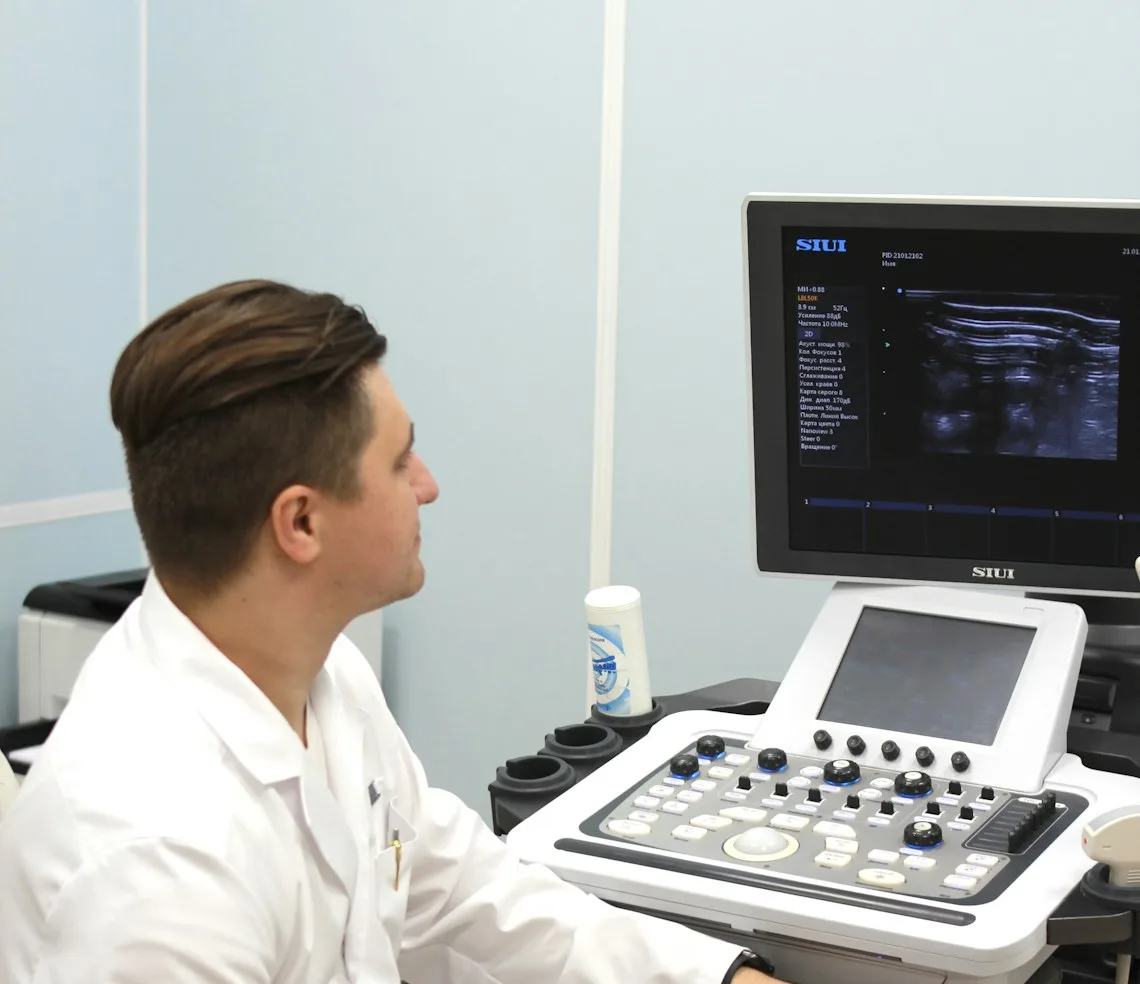 A sonographer at the ultrasound machine in the scanning room