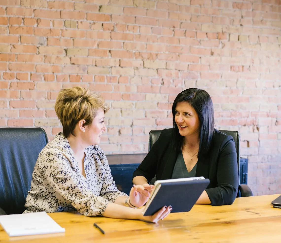 A business consultant working through a plan with an owner at a meeting table